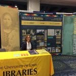 Janet Weaver in front of Migration is Beautiful display