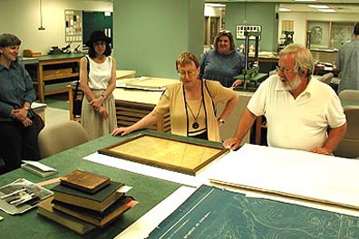 Nancy Kraft, UI Head of Preservation, and Ivan Hanthorn, ISU Conservator, evaluate a document at the light table, while Susan Hansen, Bu Wilson (both from UI) and Cindy Wahl (of ISU) look on. 