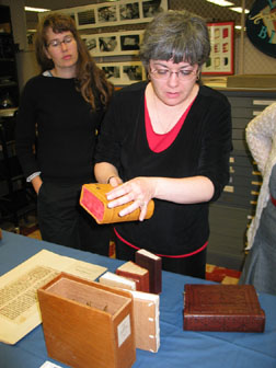 Sylvie discusses Armenian Bookbinding features using the UI Armenian binding model made by Shanna Leino. Melissa Moreton, a graduate student in Medieval history and organizer for Merian's visit, looks on.