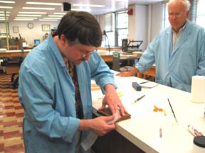 Alan applies Solvent-Set repair tissue to a book while Gary Frost looks on. 