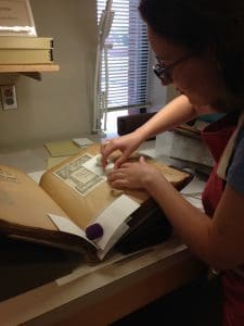 Kate is using humidification to flatten creases in the paper.  