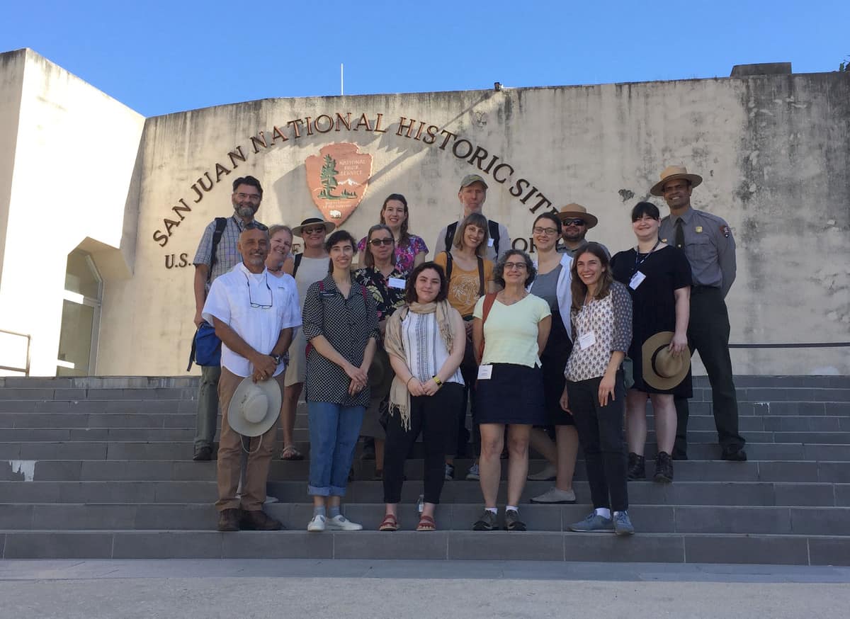 Pagan (first row, second from the left) and other participants stand in front of the San Juan National Historic Site for a group photo.