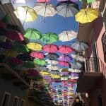 Colorful umbrellas hanging from wire about Foraleza Street.