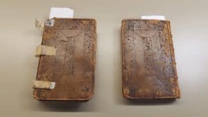 The image shows the front cover of the first book on the left and the back cover of the second on the right. They have matching designs in the leather.