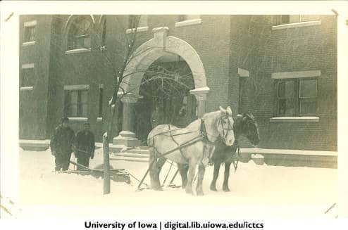  	Horses pulling a snow plow in front of Armory