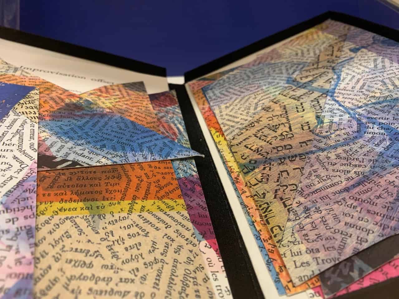 The image shows colorful papers in many sizes of triangular shapes covered in words from various languages.