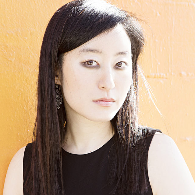 Portrait of the author, an Asian woman with long black hair. She wears a black sleeveless shirt.