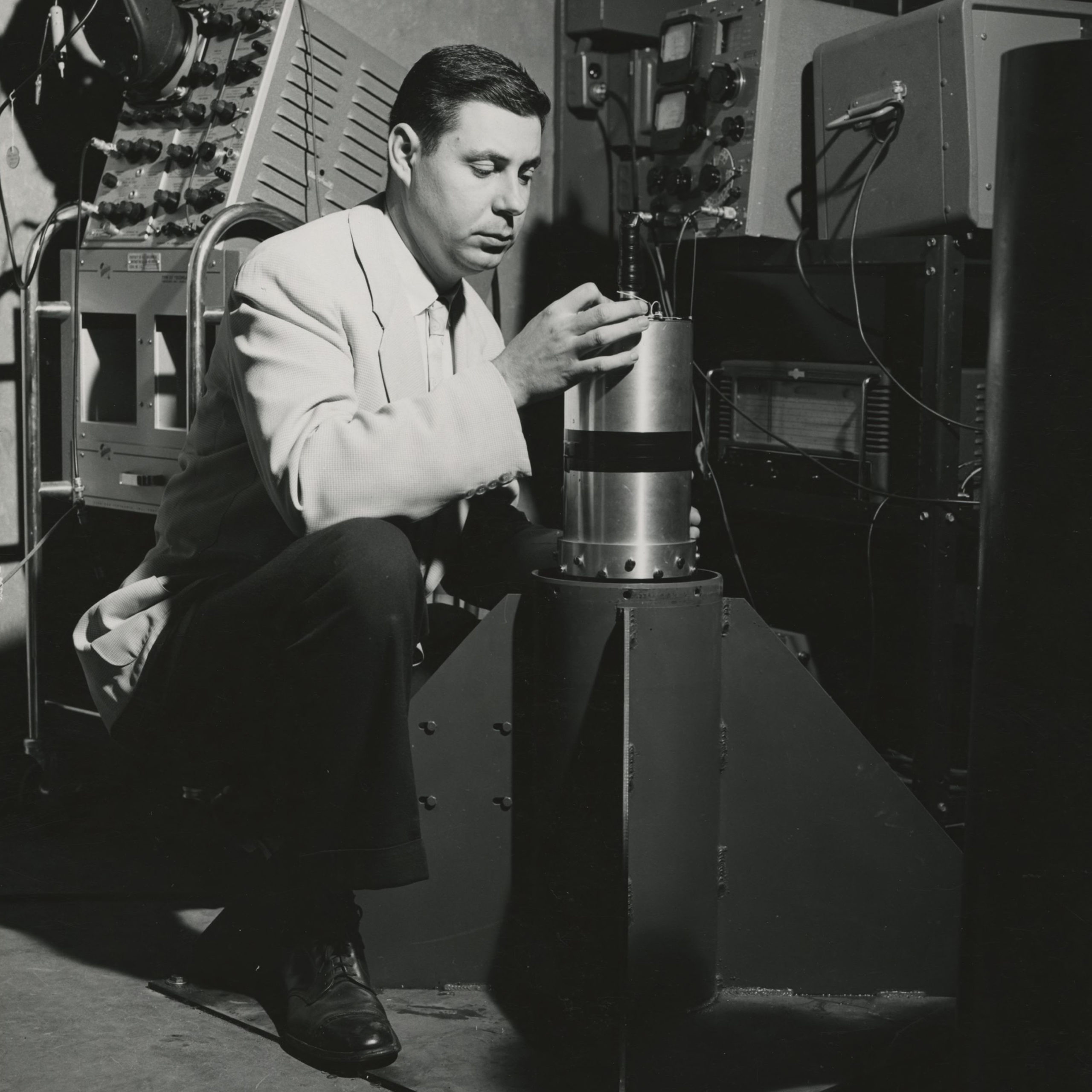 George Ludwig works on satellite equipment in a laboratory.