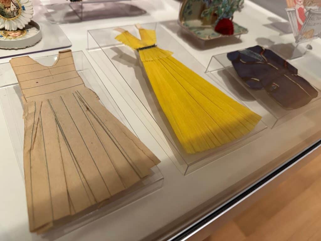 Three handmade dresses for paper dolls. One is made of lined school notebook paper and the other two are made of crepe paper. All are very delicate.