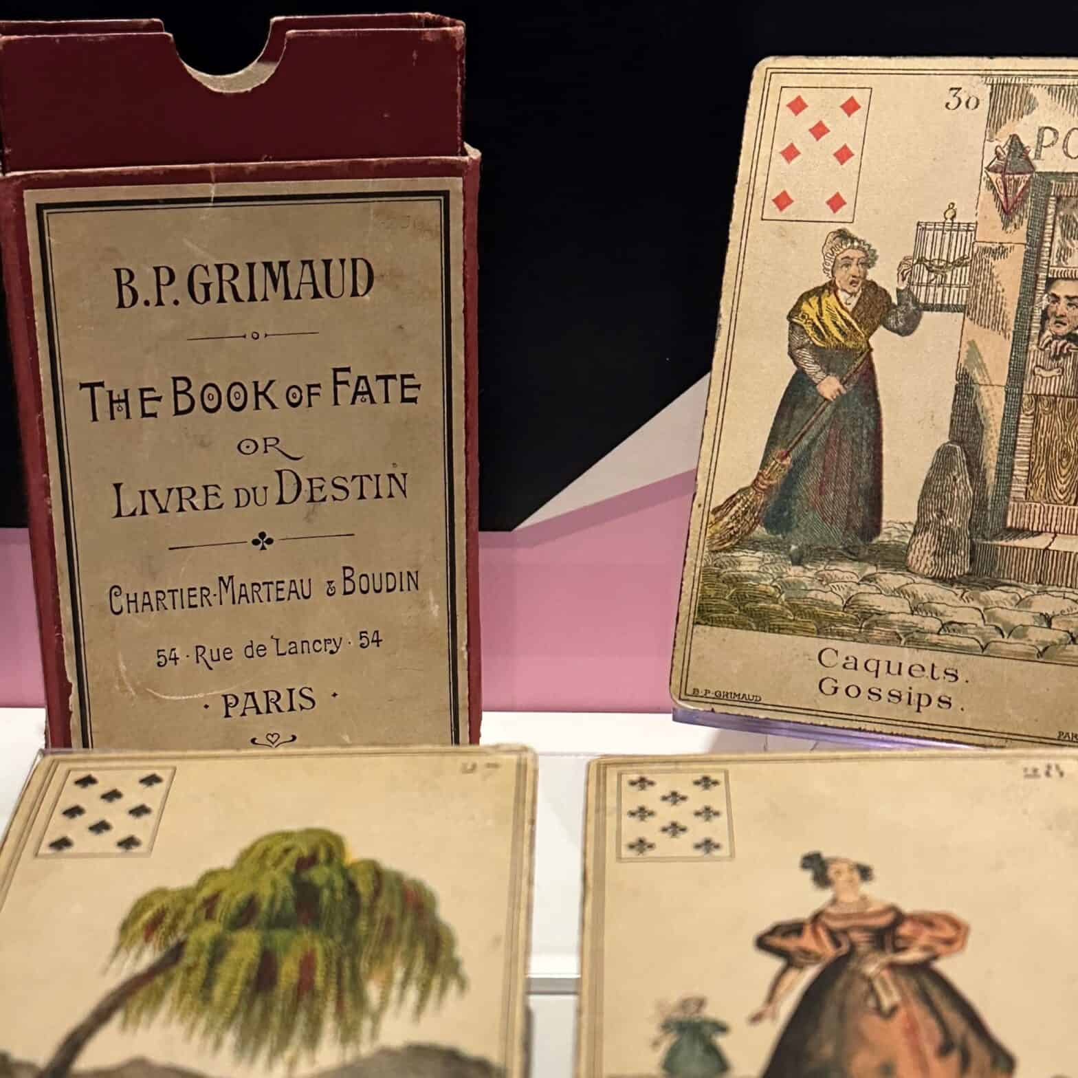 A card game box and three playing cards.