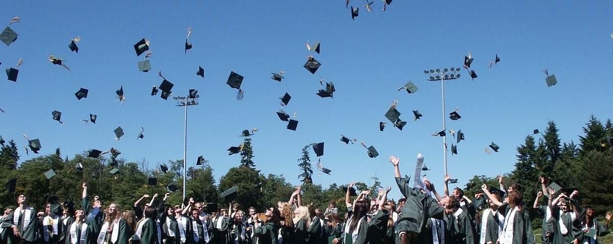 graduation caps flying in air