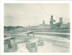 Workman standing on the seating tiers during construction of the Theatre Building, the University of Iowa, 1935 (Iowa Digital Library)