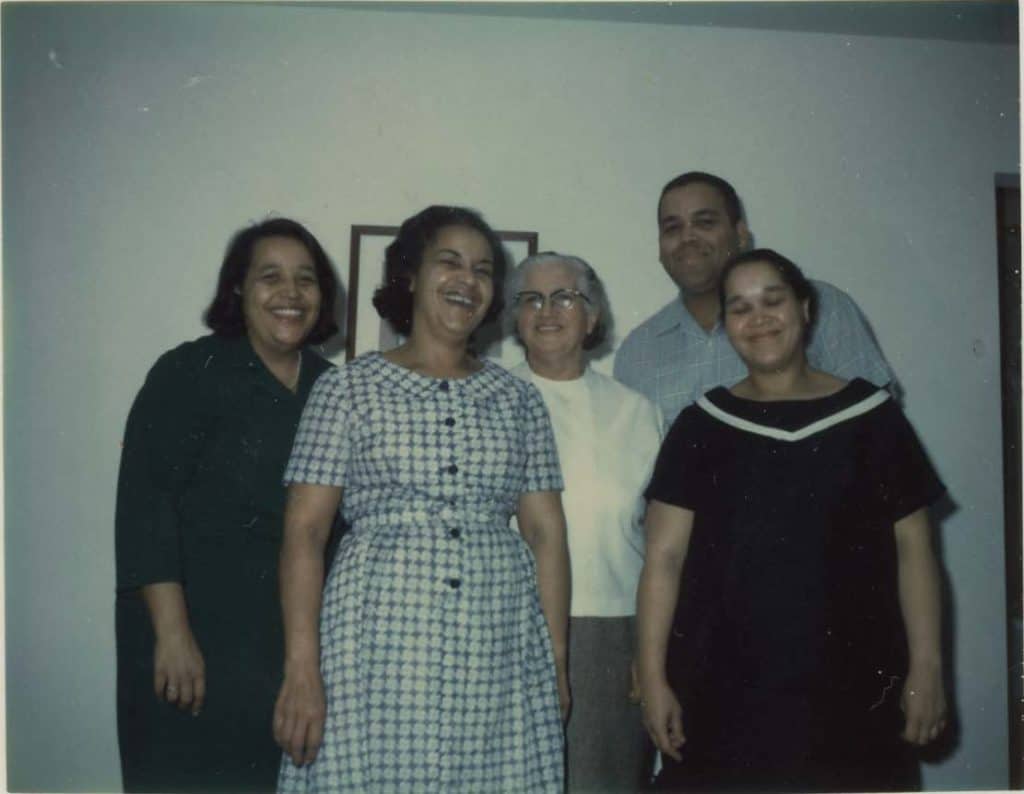 Four women and one man posing together and smiling