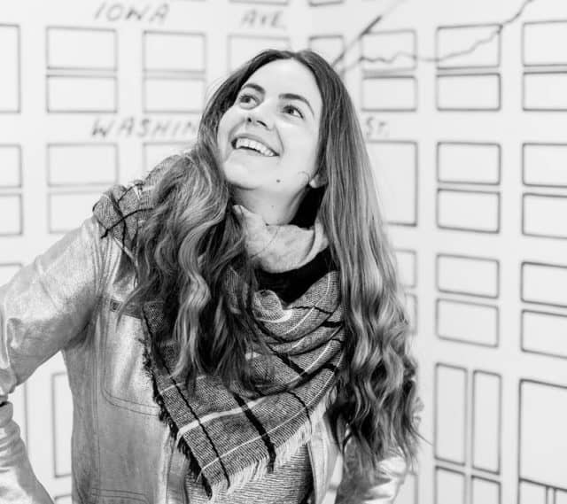 black and white image of Vero Rose Smith, white woman wearing scarf in front of map of Iowa City by Christopher Hunter