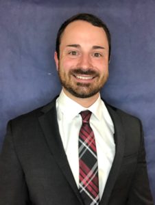 head shot photo of Joe Promes, white man, beard and mustache, black suit, tartan tie