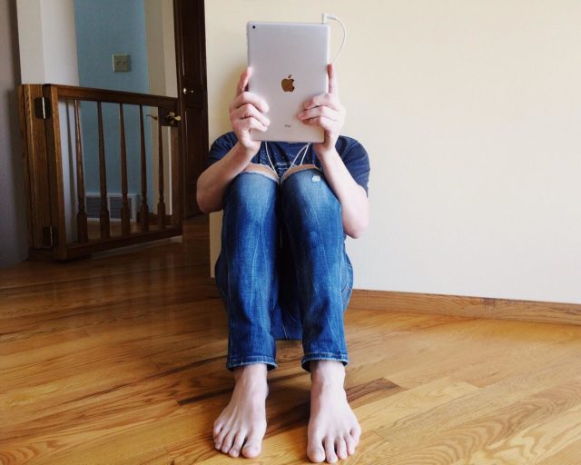 image of person reading and ipad