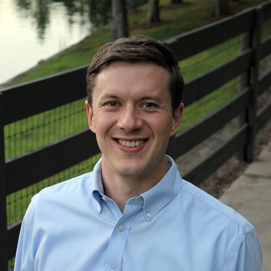 photo of Jonathan Reeder, white man, blue shirt, green background