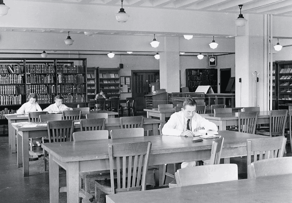 man and 2 women in white coats studying in medical library