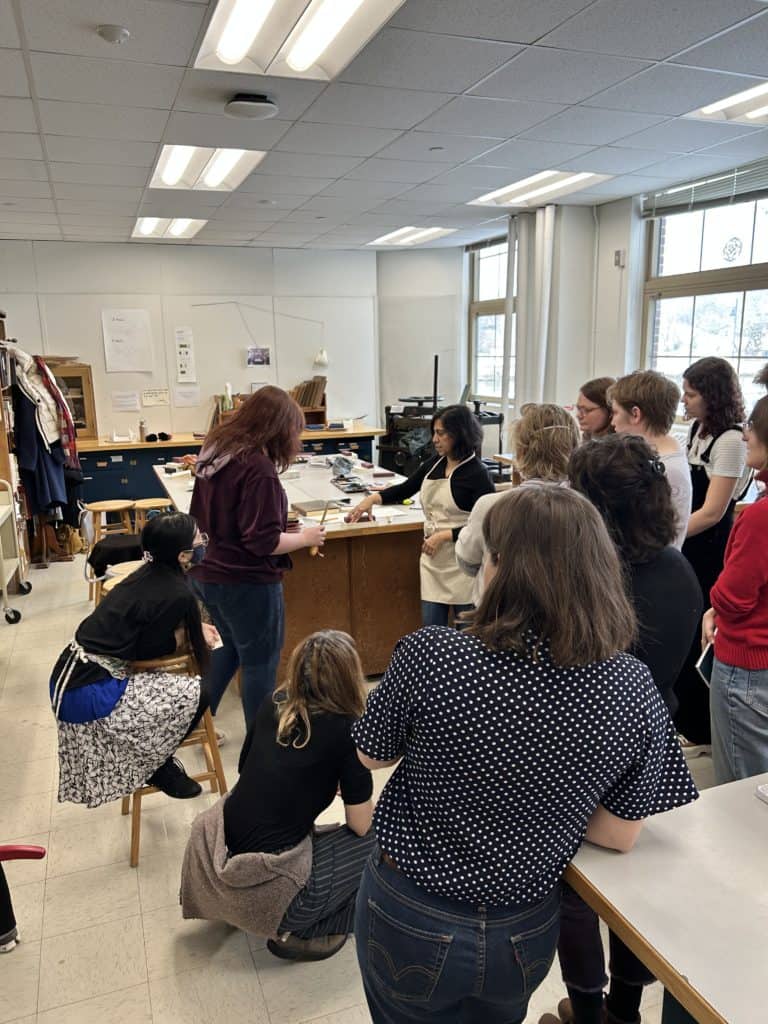 a room of people watch a presentation