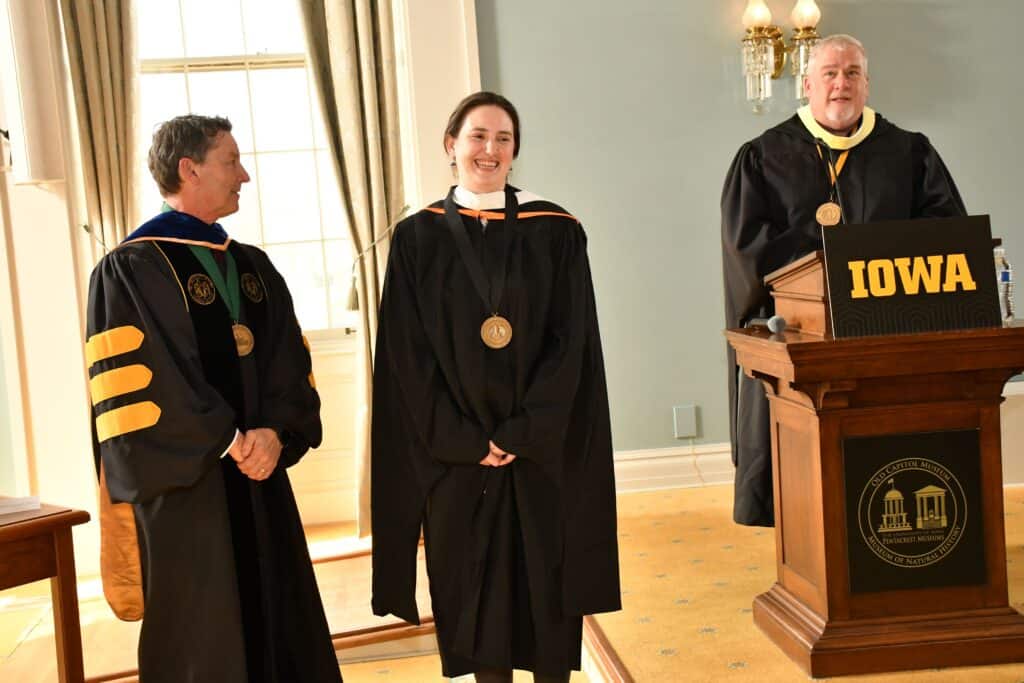 John Culshaw and Kevin Kregel present a gold medallion to Kate Orazem.