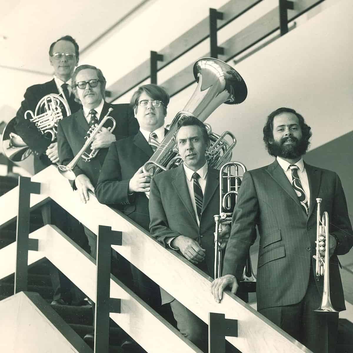 The Iowa Brass Quintet posed with their instruments on the lobby staircase of Clapp Recital Hall in the 1970s