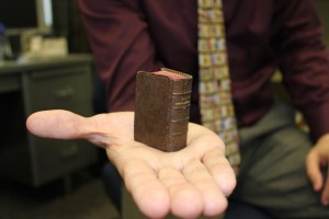 Miniature book resting on the palm of a hand