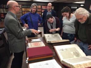 People gathered around Greg Prickman looking at books