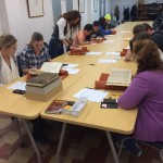 Image of a class of students examining books