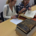 Image of two students examining a book