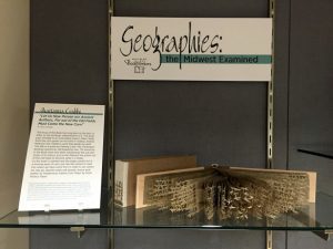 Geographies exhibition title card with example book