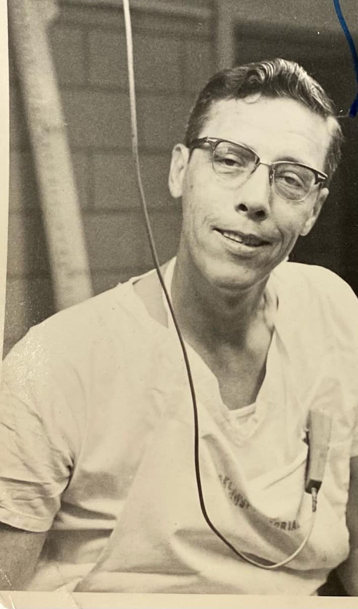 Black and white photo of Earl F. Rose with wearing horn-rimmed glasses and white scrubs