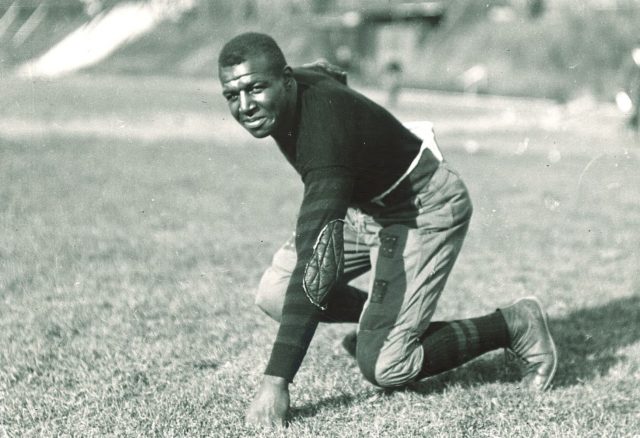 Duke Slater posing on football field
