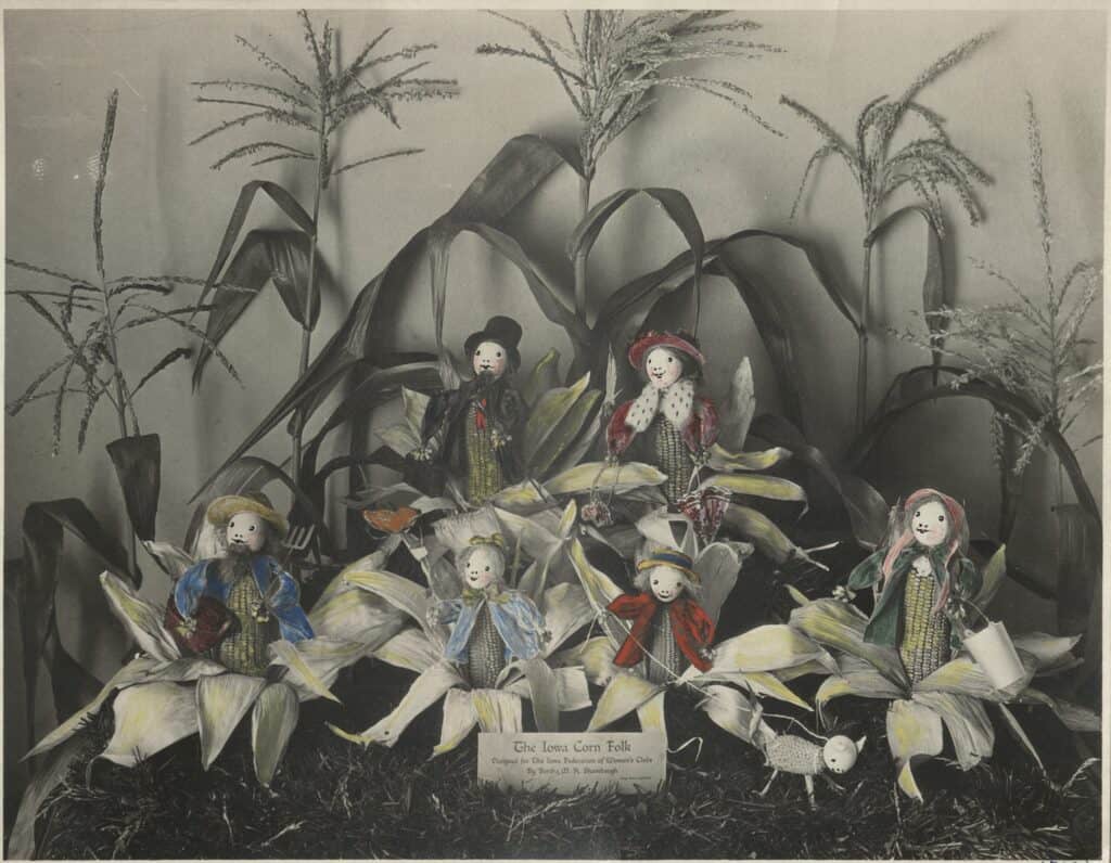 Hand-colored photo of corn dressed as people
