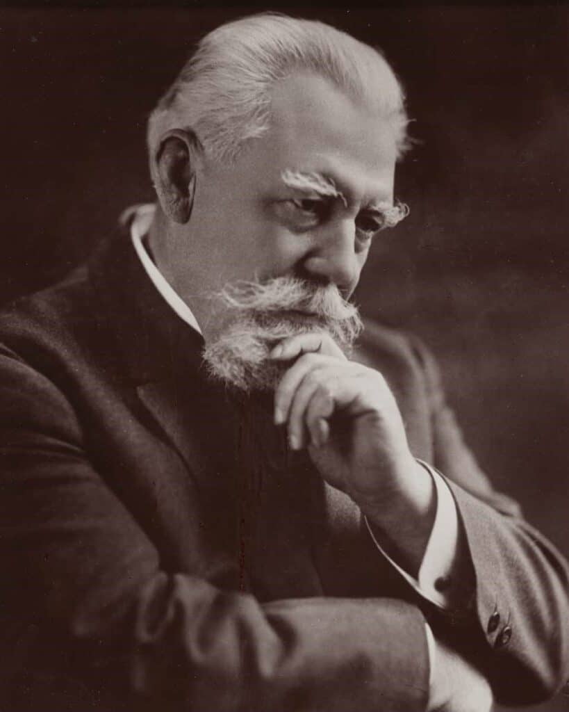 Black and White photo of Macbride, an older man with white hair, bushy eyebrows, and a well-dept beard